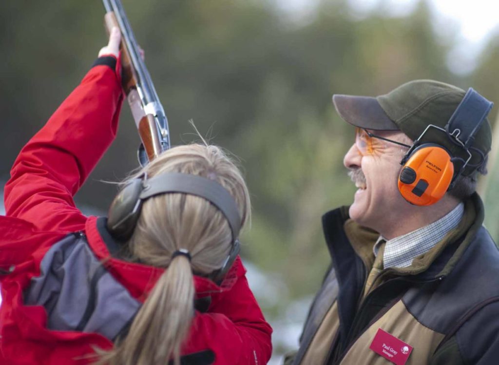 Woman at clay target range with instructor