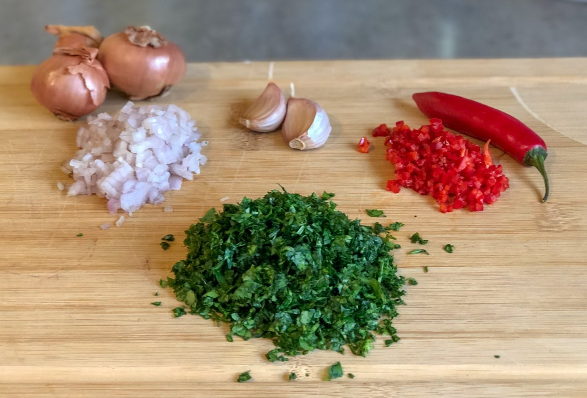 chopped ingredients for chimichurri sauce - shallot, garlic, chilli, parsley and coriander 
