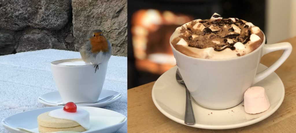 Robin warming his toes on a coffee and a hot chocolate by the fire in the Druie Cafe