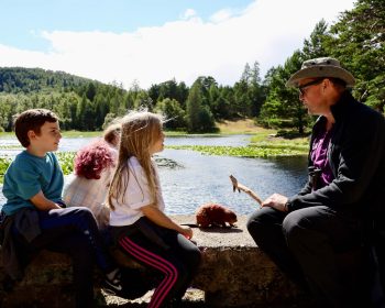 Nature Walk in Beaver habitat. Children sit on a man made dam and listen to Jonathan Willet Beaver Project Manager.
